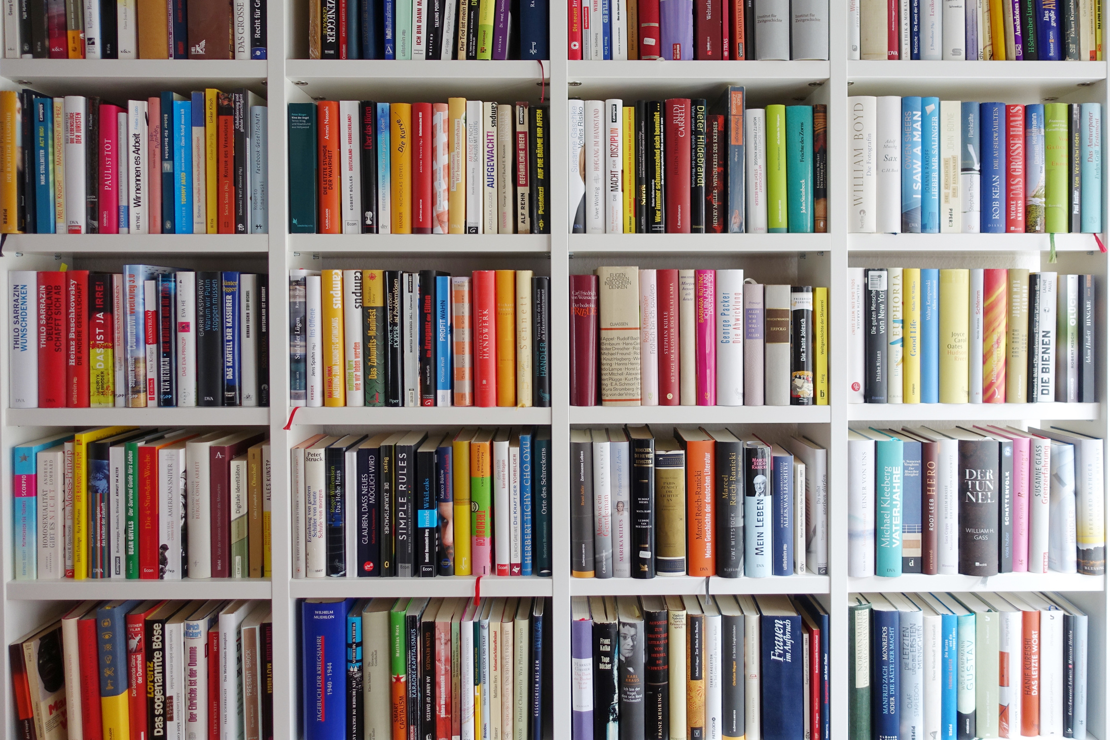White book shelves narrowly packed with german books